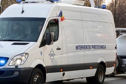 White emergency van with blue lights and a romanian flag on the roof, labeled interventie pirotehnica (pyrotechnics unit) masina interventie pirotehnica