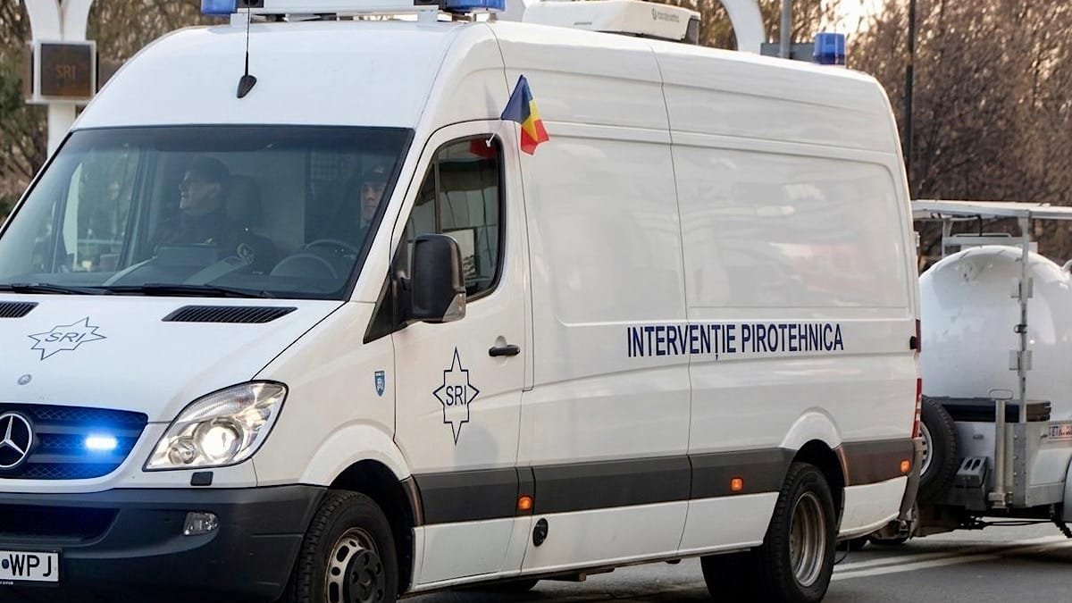 Masina Interventie Pirotehnica Stiripitesti.ro White emergency van with blue lights and a romanian flag on the roof, labeled interventie pirotehnica (pyrotechnics unit) masina interventie pirotehnica